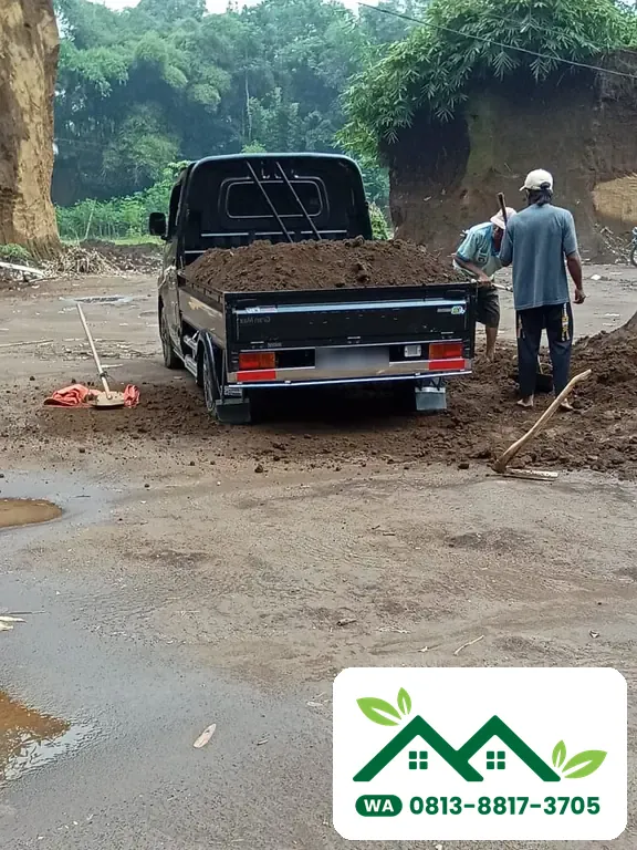 Pekerja memuat tanah subur ke bak pickup