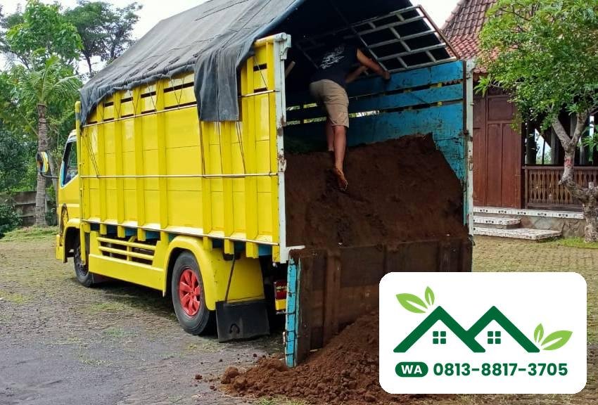 Truk kuning membongkar tanah subur di halaman